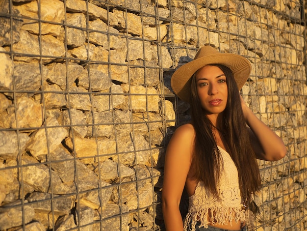 Femme touchant les cheveux près du mur de pierre