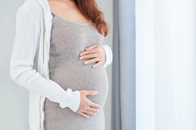 Femme touchant sa bosse de bébé