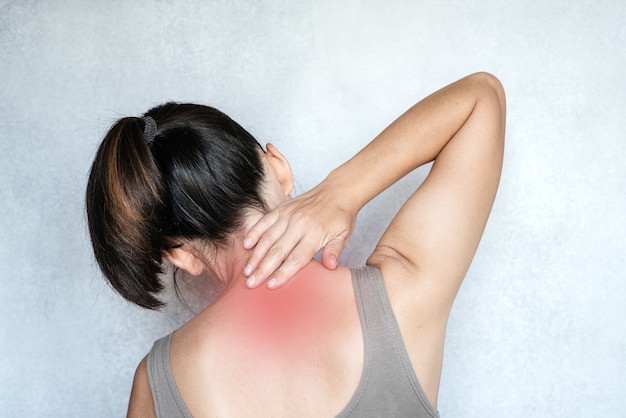 Une femme touchant son cou avec sa main, douleur au cou, exercices de soulagement de la douleur au cou