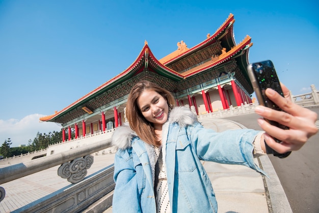 Femme de tourisme asiatique s&#39;intéresse à son téléphone intelligent dans le point de repère de Taipei