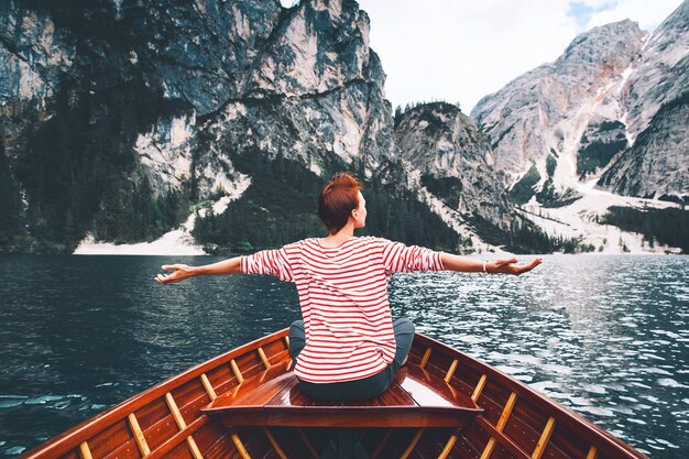 Femme de tourisme en bateau à rames traditionnel en bois sur le lac alpin italien de Braies