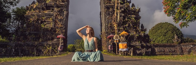 Femme de tourisme marchant à travers la porte traditionnelle hindoue balinaise candi bentar près de bedugul bratan