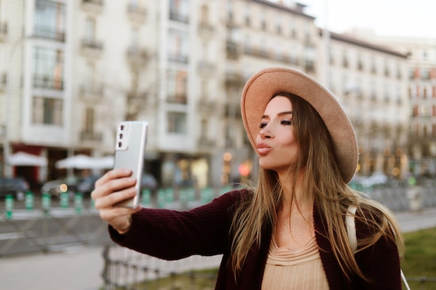 Femme de tourisme prenant un selfie à l'extérieur dans la rue