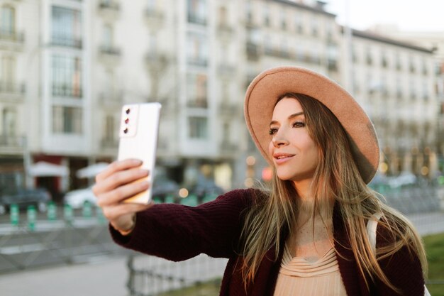 Femme de tourisme prenant un selfie à l'extérieur dans la rue