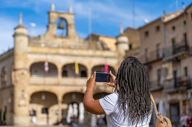 Femme de tourisme en vacances prenant une photo avec un téléphone dans le célèbre village de Ciudad Rodrigo à Salamanque