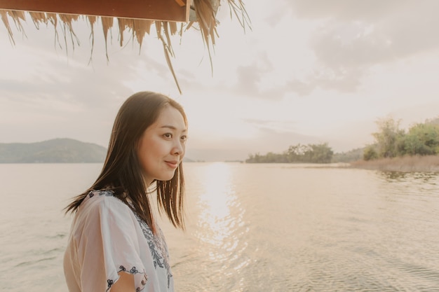 Femme Touriste Admire La Belle Nature Du Lac Avec Un Ciel De Coucher De Soleil Chaud.