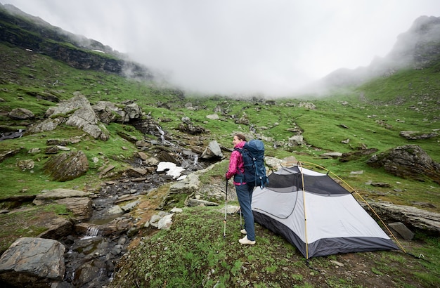 Femme touriste au sommet d'une colline dans les montagnes