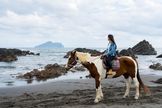 Une femme touriste à cheval à côté de la plage