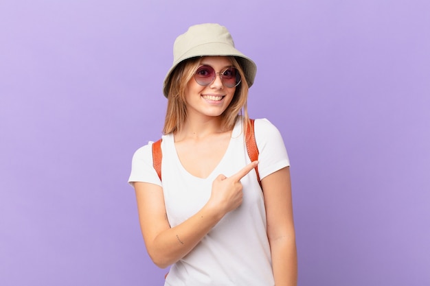 Femme de touriste jeune voyageur souriant joyeusement se sentir heureux et pointant vers le côté