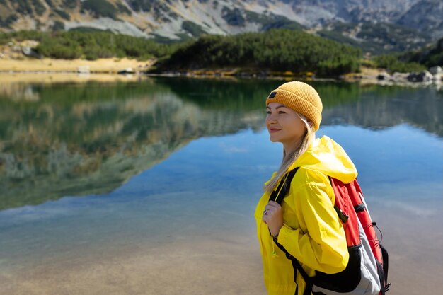 Femme touriste profitant seule de la vue sur le lac en plein air aventure de voyage dans des vacances actives mode de vie sain