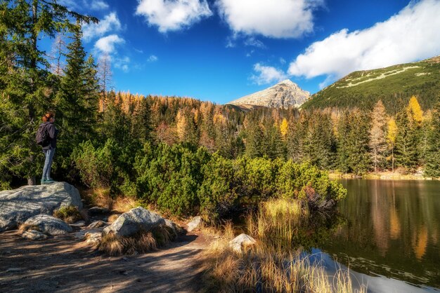 Une femme touriste sur la rive du lac de montagne Jamske pleso avec le sommet Krivan