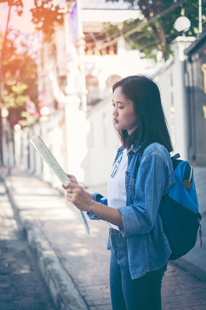 Femme touriste avec un sac à dos debout dans une rue étroite.