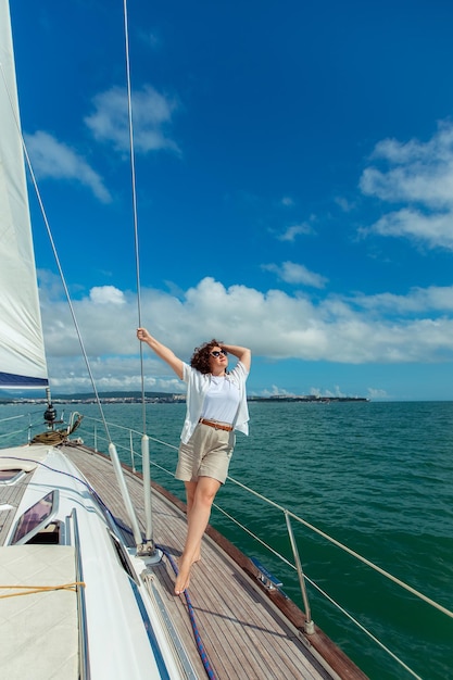 Femme touriste voyageuse à lunettes de soleil un jour d'été sur un yacht dans la mer