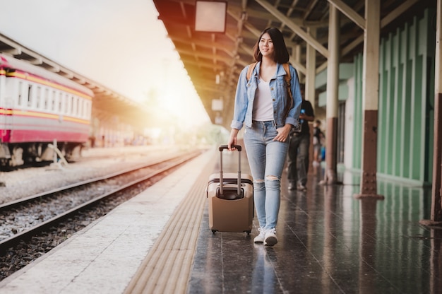 Femme touristique avec des bagages à la gare