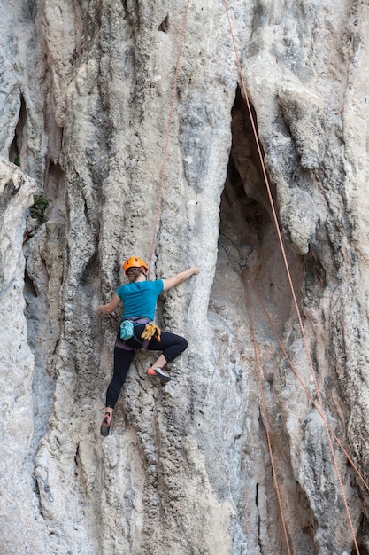 Femme touristique escalade sur un mur calcaire sur la province de Krabi en Thaïlande.