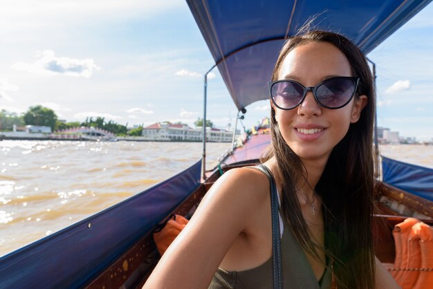 Femme touristique explorant la ville de Bangkok avec bateau fluvial