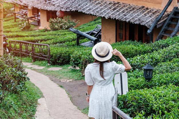 Une femme touristique heureuse en robe blanche profite du magnifique jardin de thé Voyageur visitant le village thaïlandais de Ban Rak Mae Hong Son Thaïlande voyage vacances et concept de vacances
