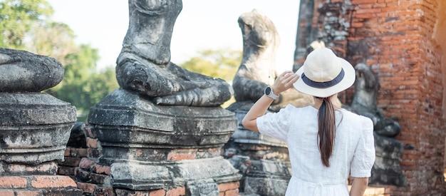 Femme touristique en robe blanche visitant l'ancien stupa du temple Wat Chaiwatthanaram dans le parc historique d'Ayutthaya, l'été, l'Asie et le concept de voyage en Thaïlande