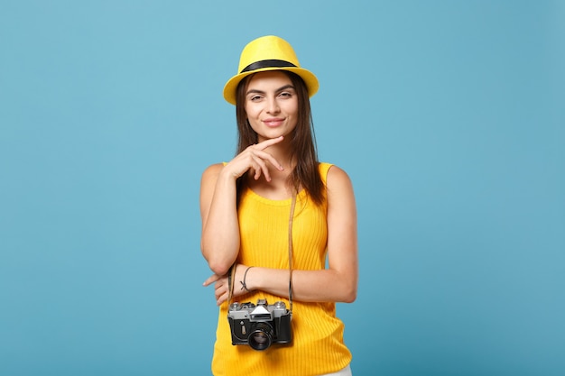 femme touristique en vêtements décontractés d'été jaune et chapeau avec appareil photo sur bleu