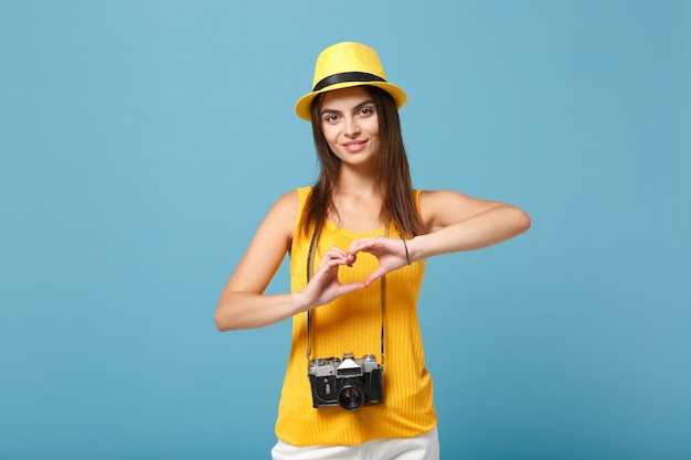 femme touristique en vêtements décontractés d'été jaune et chapeau avec appareil photo sur bleu