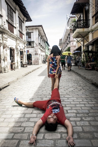 Une femme traînant un homme dans la rue.