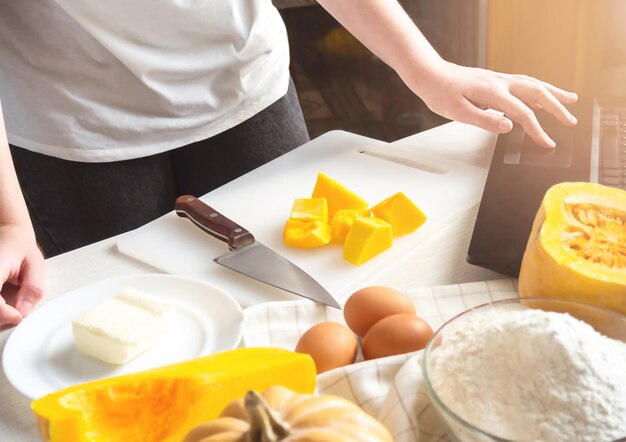 Une femme tranche une citrouille Le processus de fabrication d'une tarte à la citrouille pour Thanksgiving