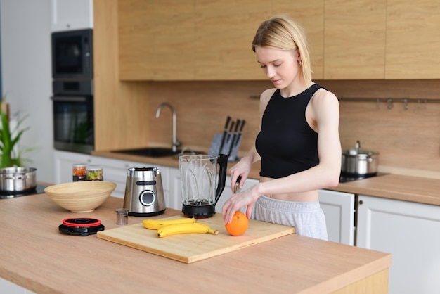 La femme tranche le fruit pour le jus