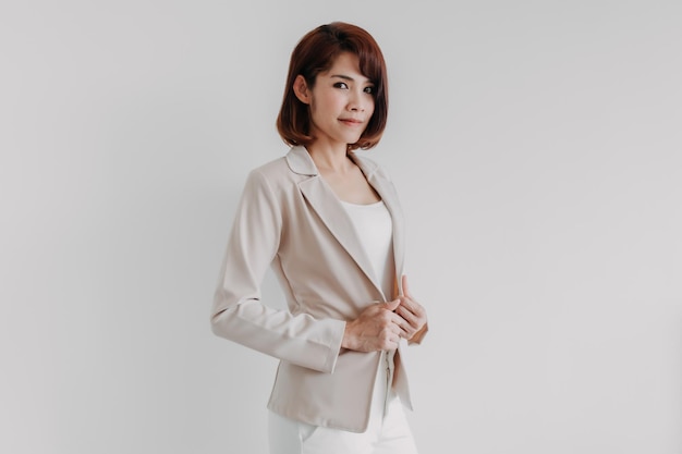 Femme de travail asiatique confiante en blazer beige isolé sur blanc