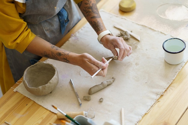 Femme travaillant avec de l'argile dans un atelier de poterie pendant une masterclass