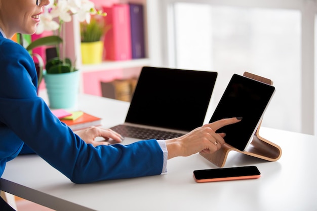 Femme travaillant au bureau et utilisant différents appareils technologiques