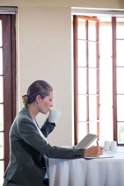 Photo femme travaillant et buvant un café