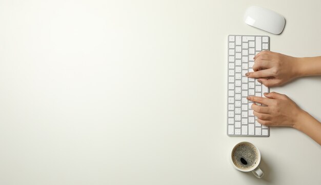 Femme travaillant sur un clavier moderne sur fond blanc