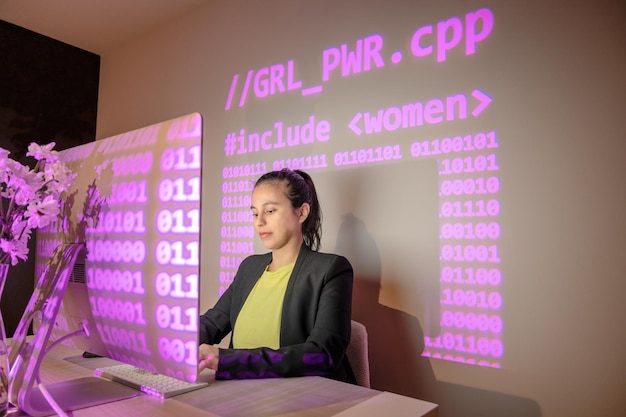 Femme travaillant sur le code de programmation avec projection de pouvoir des filles et code numérique rose
