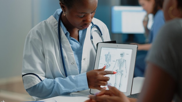 Femme travaillant comme médecin tenant une tablette avec une image squelette