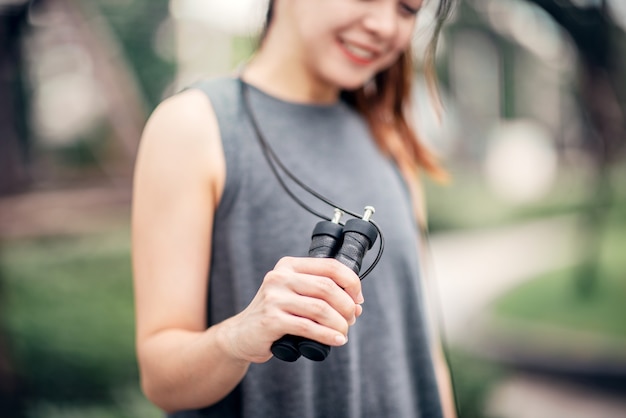 Femme travaillant avec corde à sauter dans un parc.