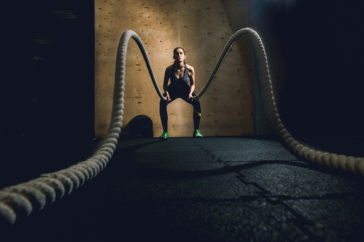 Photo femme travaillant avec des cordes de bataille