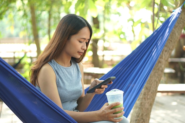 Femme travaillant dans un café en ligne voir les bénéfices par téléphone