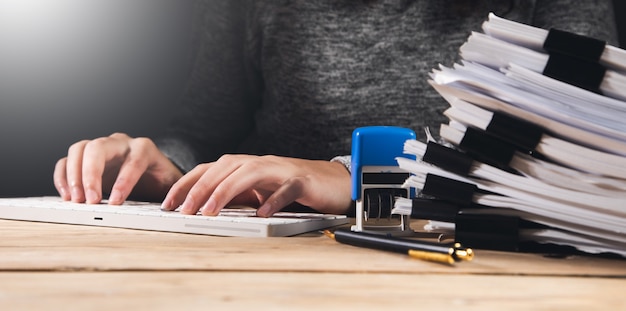 Femme travaillant dans un ordinateur avec des documents et un sceau sur la table