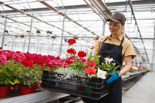 Femme travaillant dans une serre avec des fleurs