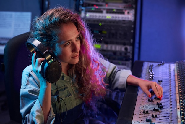 Femme travaillant dans un studio d'enregistrement numérique