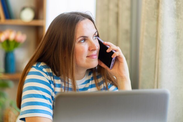 Femme travaillant à domicile pour un appel téléphonique