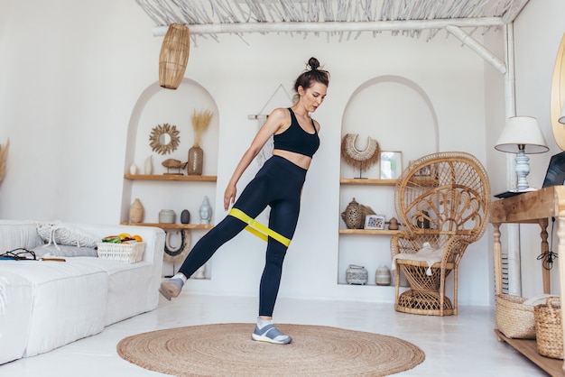 Femme travaillant à la maison avec une bande élastique.