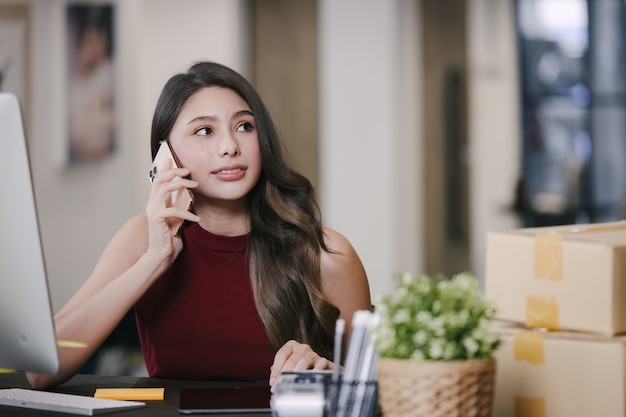 Femme travaillant à la maison avec ordinateur portable et téléphone portable