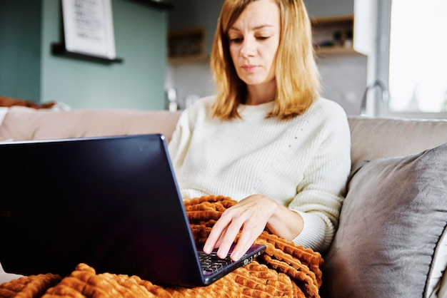 Femme travaillant à la maison avec ordinateur portable