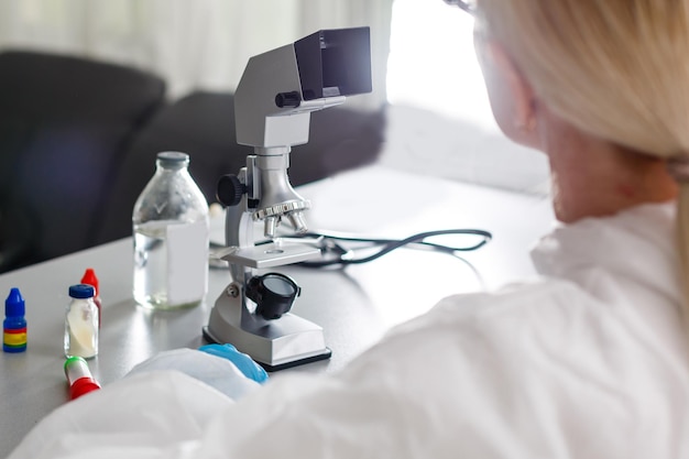 Femme travaillant avec un microscope en laboratoire