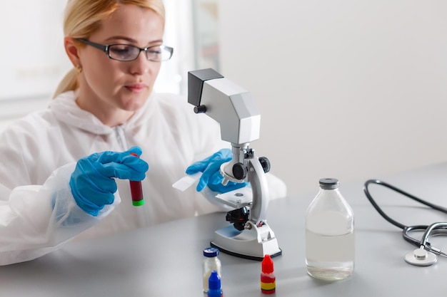 Femme travaillant avec un microscope en laboratoire
