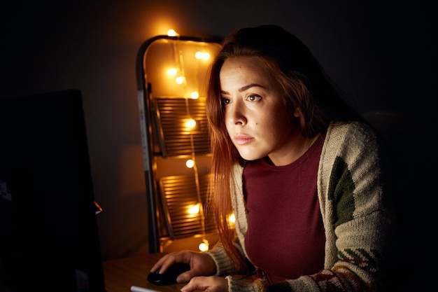Femme travaillant la nuit utilise un ordinateur de bureau pour démarrer sa petite entreprise