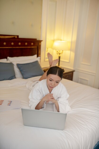 Une femme travaillant avec l'ordinateur dans sa chambre