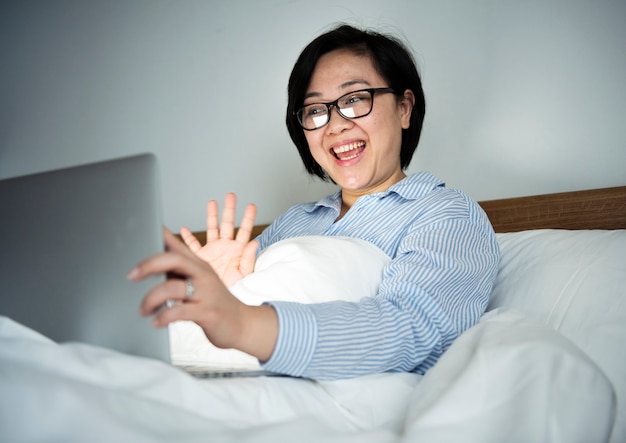 Une femme travaillant sur un ordinateur portable au lit