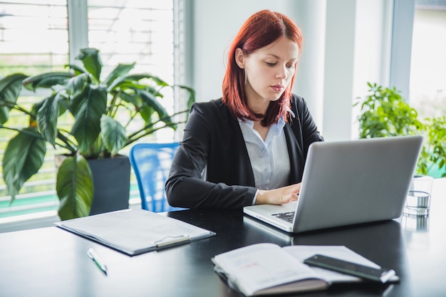 Femme travaillant avec un ordinateur portable dans un bureau moderne